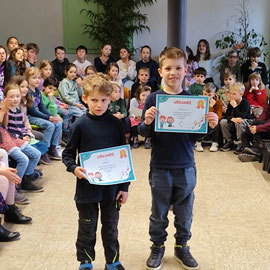 Die zwei Jungen der Löwenklasse halten ihre Urkunden in der Hand