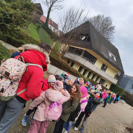 Die Erst- und Zweitklässler stehen in Zweierreihen und warten auf den Bus.