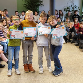 Die vier Jungen aus der Löwenklasse halten ihre Urkunden in der Hand