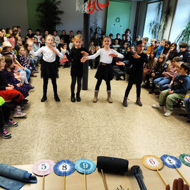 Vier Mädchen aus Klasse drei tanzen in einer Reihe