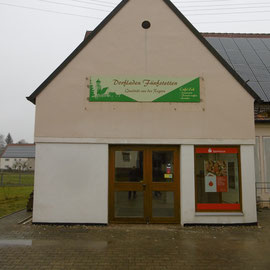 Das Dorfladenloge prangt am Giebel.