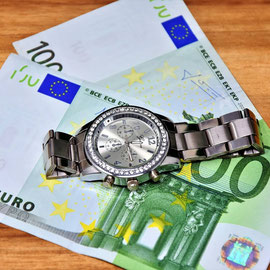 Eine Uhr und Geldscheine.