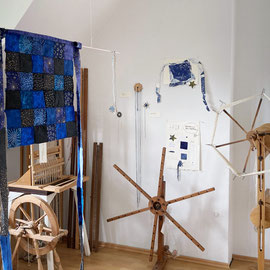 Nadja Hormisch, "Das Sternenschürzchen" (Vorderansicht); Baumwolle, handgenäht in Patchworktechnik. Rechts dahinter Skizzen zum Sternenschürzchen, Garnsterne, Sternseide, Knüpfsterne, Sternhaspeln.