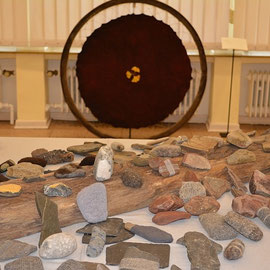 Arbeit von Barbara May (vorne): "SteinReich" (2012), Raumobjekt mit Steinen, mit versch. Techniken umhüllt, vergoldet; versch. Wollen, z.T. selbstgesponnen u. pflanzengefärbt; Arbeit von Beate Lambrecht (hinten): "Kraftrad" (2015)