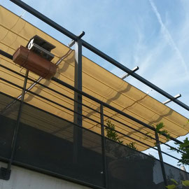 Pose d'une toile rétractable qui protège des UV sur une pergola en acier