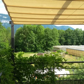 Mise en place La toile coulissante sur une pergola en acier. La toile permet une absorption thermique et protège du soleil.