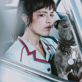 portrait couleur de la comédienne Vimala Pons dans une voiture accompagnée d'un chien 