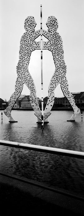 Der Molecule Man in Berlin als vertikales Panorama-Foto in Schwarzweiß