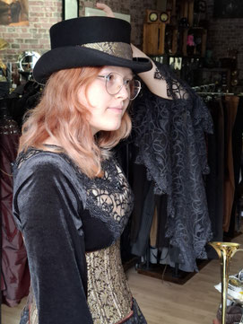 Eine Kundin betrachtet ihr erstes Steampunk-Outfit für Anfänger im Spiegel bei der Stilberatung in der Steampunk-Station-Bochum