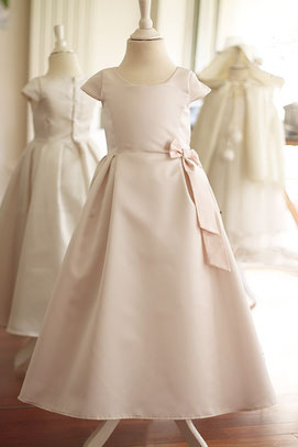 Robe longue de cérémonie pour petite fille en satin ivoire et noeud en taffetas rose poudré. Modèle robe de cortège mariage Margaux créé par Fil de Légende. Magasin vêtements d'enfants Paris, Neuilly-sur-Seine. Expéditions en France et à l'international.