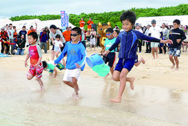 テープカット後、子どもたちが一斉に海へと飛び込んだ=21日午前、マエサトビーチ