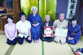 弥勒役を引き継いだ前盛善治さん(右から2人目)と父の善昭さん(3人目)=24日午後、白保集落