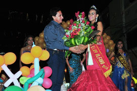 Gema Bazurto Zamora, reina de la Parroquia Eloy Alfaro de la ciudad de Manta, recibe flores de manos del concejal Johnny Mera. Manta, Ecuador.