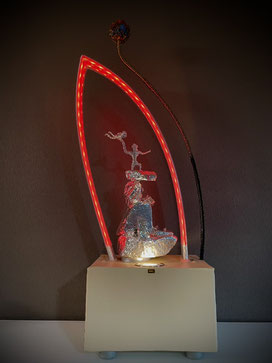 Skulptur ATARAXIE von Andreas Alka alias FLoYd mit roter LED-Beleuchtung, abstrahierte Figuren aus Draht auf lackiertem Sandstein, umschlossen von leuchtendem Plexiglasbogen.