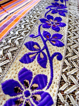 Close-up of purple & silver floral ribbon border on Indian cotton throw