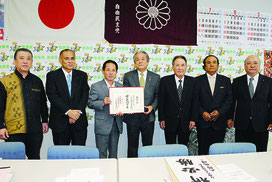 自民県連の照屋会長から公認証を受け取る外間氏
