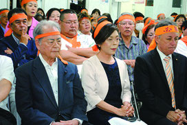 沖縄市長選で落選が決まり、厳しい表情を見せる諸見里氏(中央)ら=22日午後10時過ぎ、選対本部