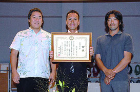2016年度県青年農業者会議、プロジェクト発表で最優秀賞に輝いた宜野座安剛さん(中)と関係者ら=28日午後、県男女共同参画センターてぃるる(那覇市)