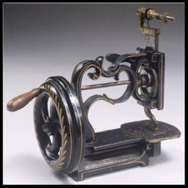 Side view of the same vintage White brand sewing machine, showcasing its detailed openwork metal frame and ornate gold embellishments.