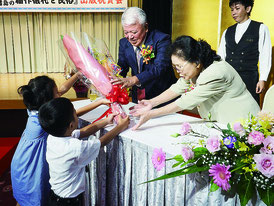 親族から花束を受け取る石垣繁さん=11日夜、市内ホテル