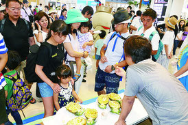 石垣空港で特産品のパインを試食する観光客=2016年8月