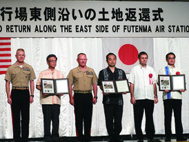 普天間基地一部の返還式典で返還記念証が翁長知事らに贈呈された=1日、宜野湾市のラグナガーデンホテル