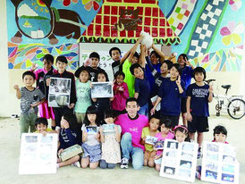 竹富小学校に雪を届けた川原さん(中央)と大喜びの児童たち=22日、竹富小中学校