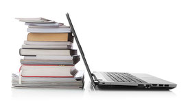 Ein Stapel Bücher und ein aufgeklappter Laptop
