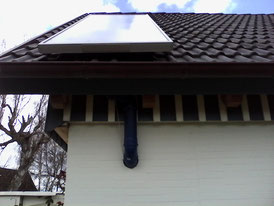 Befestigung auf dem Dach und Luftrohr außen um die Beton-Geschoßdecke herum geführt nach unten ins EG