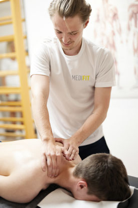 Ein Physio-Therapeut massiert einen Patienten