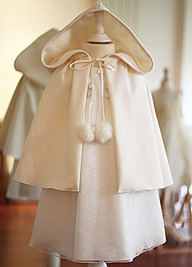 Cape cérémonie enfant laine et cachemire ivoire avec large capuche et fermeture pompons. Fait-main en France. Atelier à Neuilly-sur-Seine. Envois dans toute la France. Cortège mariage Paris.