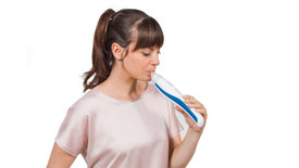 Durchführunf eines FeNo Test, indem eine Frau in das Gerät atmet 