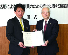知的財産の活用による産業振興のための協力に関する協定を結んだ中山市長(左)と渡邉会長=13日、市役所庁議室