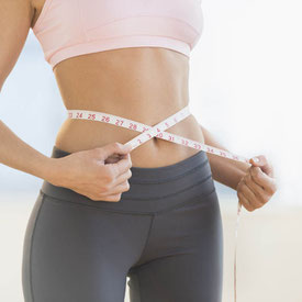 Girl measuring the amount of weight she has lost.