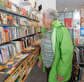 A passenger stands in front of shelves of hundreds of children's books in the gift shop