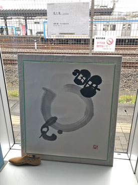 関沢　優　墨アート作品「兎と亀」　後ろに相鉄線の電車が見えます。