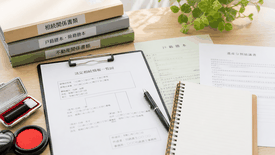 相続手続きに必要な戸籍書類・印鑑・書類一式が並ぶ机上風景