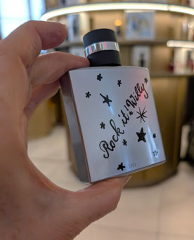 Ein exklusives Geschenk aus München: Handgemaltes Sterndesign und 'Rock it! Willy' Schriftzug auf einem Parfümflakon bei Breuninger