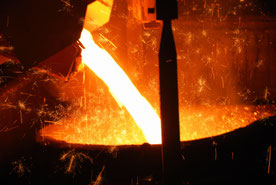 Flüssiges Metall wird in einen großen Behälter gegossen.