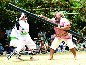 川平結願祭独特の三人棒が披露された=17日午後、群星御嶽