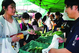 「特産島ごちそう祭」で、石垣島産の野菜を買い求める市民=25日午前、市健康福祉センター中庭