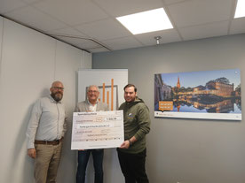 Marcel Schwarzwälder und Stefan Babis von den Buxtehuder Stadtwerken bei der Spendenübergabe an Lars Neuber, Jugendleiterreferent beim SJR - Foto: SWB