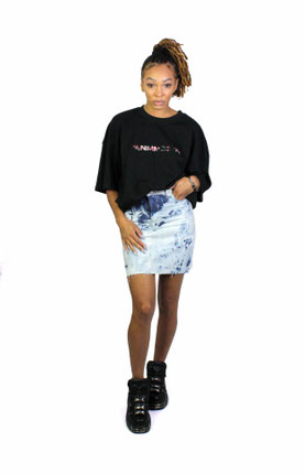 model wearing black print t-shirt and denim skirt