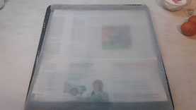 Auf das Backblech ein Blatt Zeitungspapier und darauf das Backpapier legen