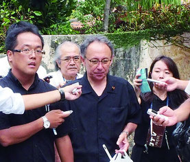 対馬丸慰霊祭に参列し、喪服姿で会場を後にする玉城氏(写真中央)=22日、那覇市内