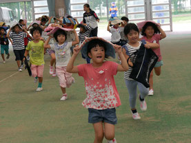 走って避難する平真小学校の児童ら=22日午前、石垣市中央運動公園内