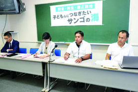 記者会見する新里代表(右から2人目)ら=20日午後、登野城地区