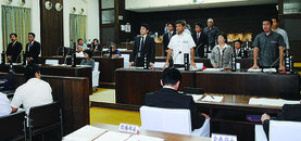 ヘリパッド反対派を批判する意見書に起立して賛成する与党(右側)=24日午前、議場