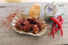 Currywurst Schwarz Hot mit Chilis Brötchen und Chiliglas mit Aufschrift Scotch Bonnet red