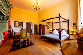 Hotelzimmer für bis zu 4 Personen mit Himmelbett, Kamin, Tisch und eigenem Badezimmer auf Schloss Arenfels im Tausentalerzimmer   